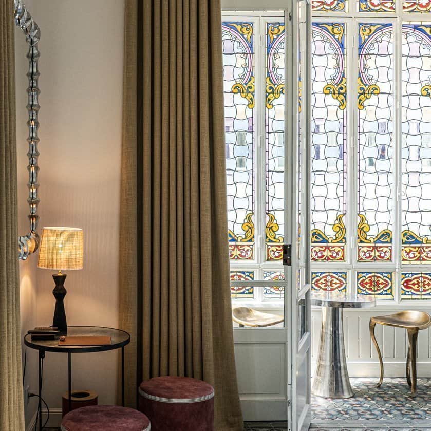 Fenêtre vitraux, miroir et table dans Suite Junior à l'Hôtel Le Mosaïque.