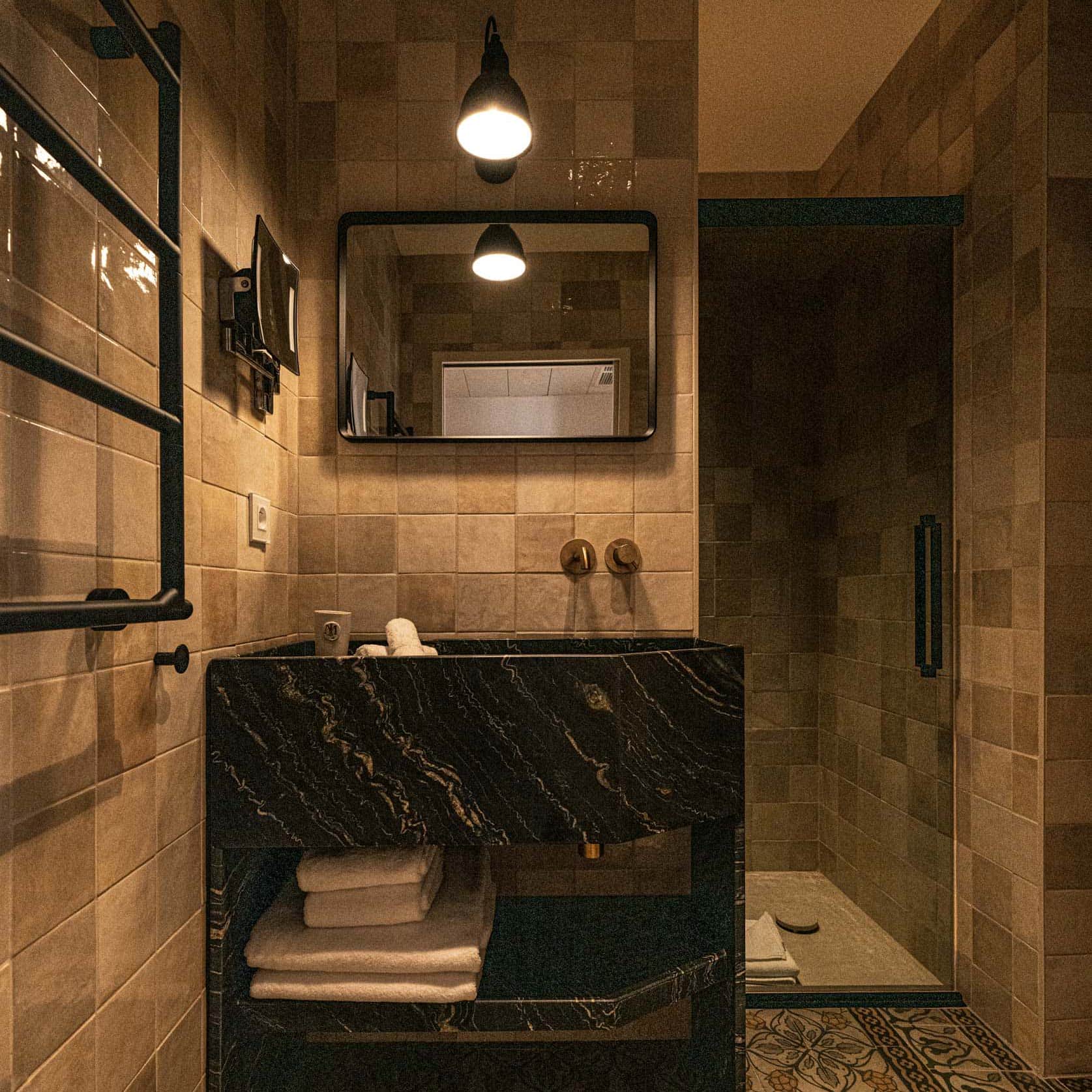 Salle de bain Suite Junior avec miroir, lavabo et douche à l'Hôtel Le Mosaïque.