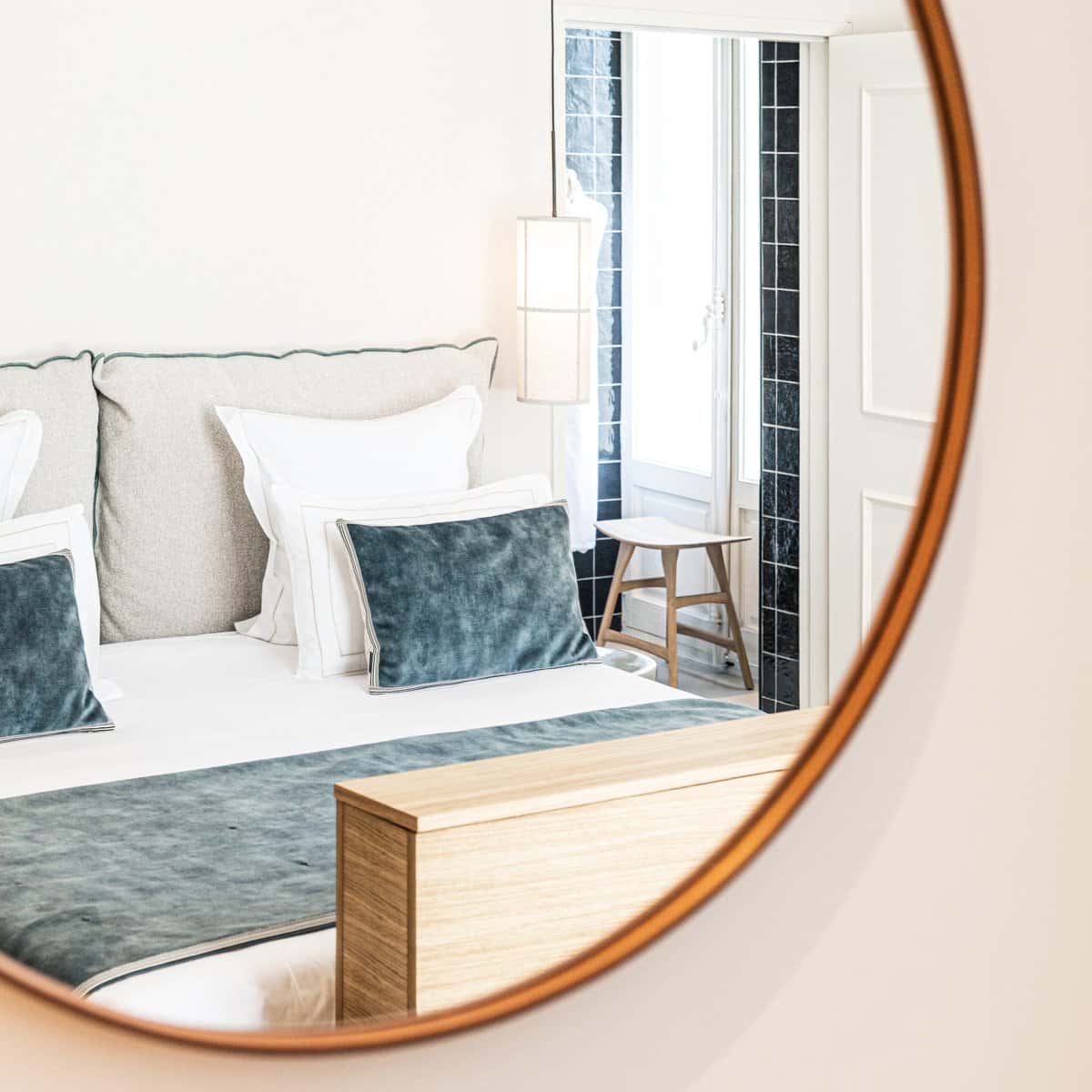 Gros plan sur le lit bleu et le miroir dans une chambre double deluxe de l'Hôtel Le Mosaïque, détails soignés et élégants.