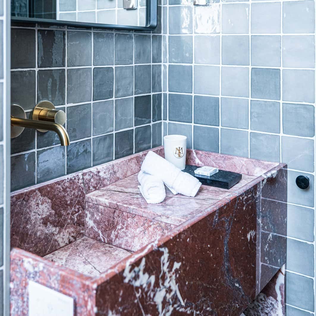 Gros plan sur le lavabo de la salle de bain deluxe de l'Hôtel Le Mosaïque, élégance et propreté.