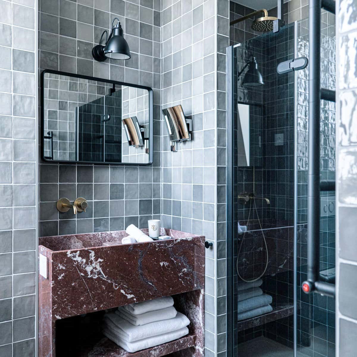 Lavabo et douche dans la salle de bain d'une chambre double deluxe à l'Hôtel Le Mosaïque, finitions haut de gamme.