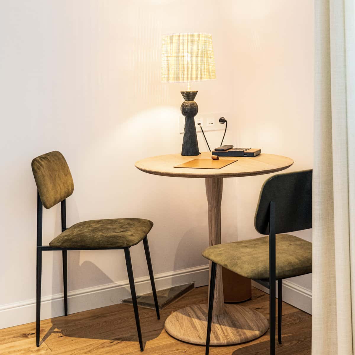 Table et chaises dans une chambre double deluxe de l'Hôtel Le Mosaïque, idéal pour un moment de détente.